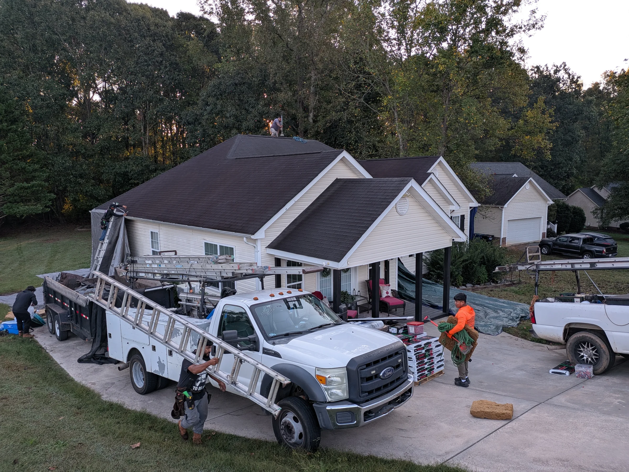 Owner-supplied view of a roofing crew and worksite at a residential property